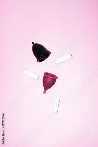 Two different sized period menstrual cups and tampons with flashlight photo