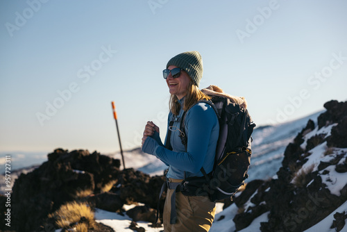 Woman in mountain clothes hiking in snowy mountains