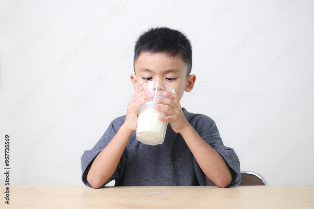 Asian child drinking milk on white background. Smiling of Asian boy with a glass of milk. Asian child drinking milk on white background. Smiling of Asian boy with a glass of milk.