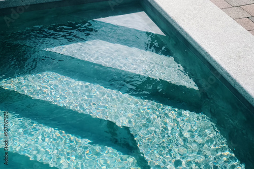 Steps in the pool with blue ceramic tile mosaic. Relax in the backyard of a country house