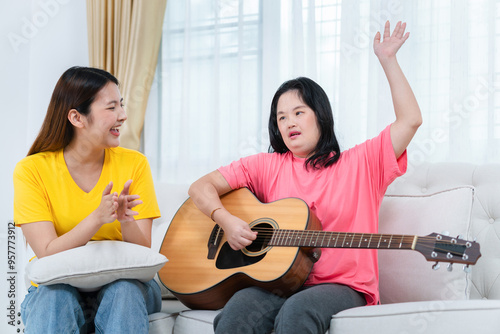 Young Asian woman friend having fun together while singing and playing the guitar in living room at home