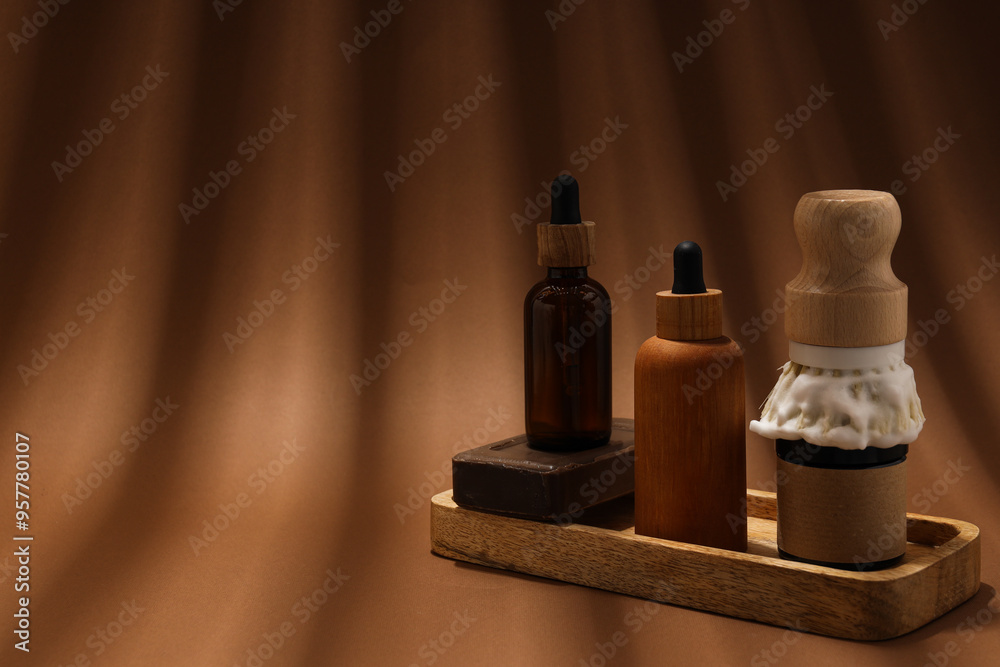 Men's shaving tools, soap and cosmetics bottles on brown background, space for text Men's shaving tools, soap and cosmetics bottles on brown background, space for text