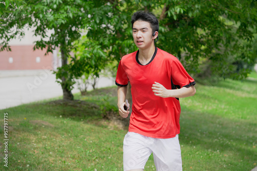 A young man is jogging with music in the city.