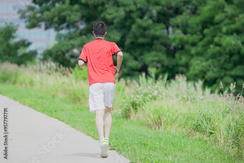 A young man is jogging with music in the city.