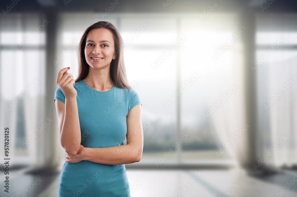Young happy woman posing in studio on window background Young happy woman posing in studio on window background