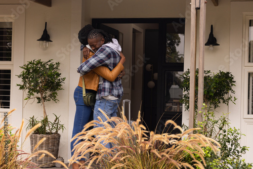 Hugging, african american couple reuniting at home, expressing love and happiness, copy space photo