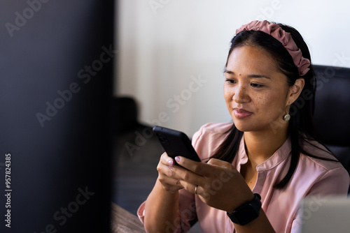 Using smartphone, woman smiling and reading messages in office, copy space