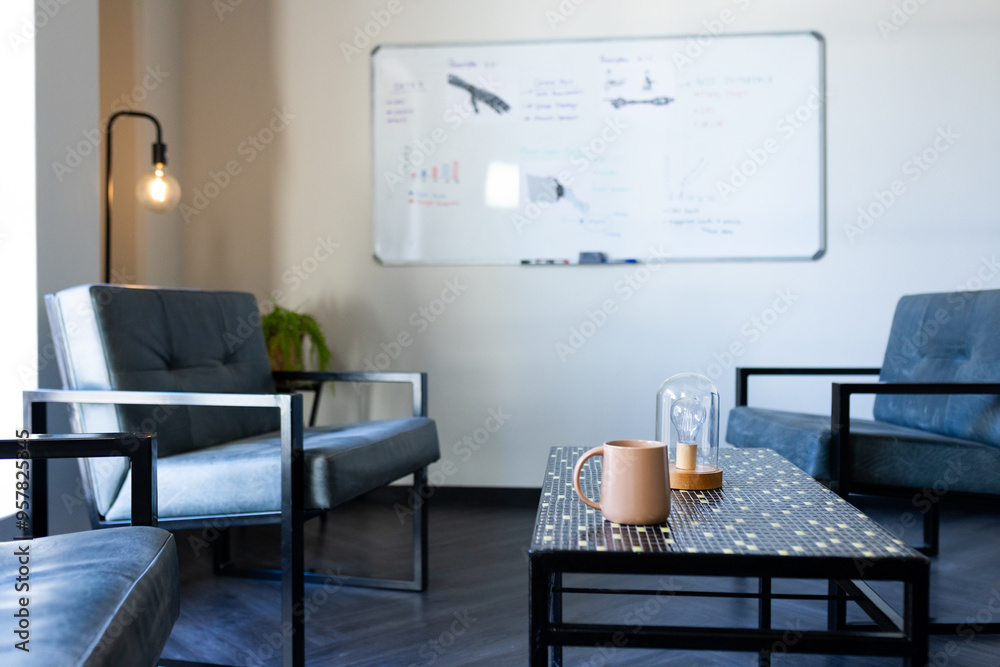 Modern office with chairs and table, whiteboard in background, cozy atmosphere, copy space Modern office with chairs and table, whiteboard in background, cozy atmosphere, copy space