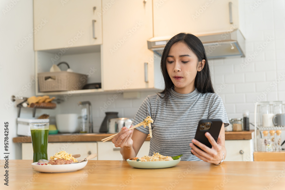 Asian Girl eating Thai food in kitchen counter Home delivery food feeling happy Asian Girl eating Thai food in kitchen counter Home delivery food feeling happy