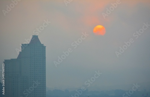 City sunrise through fog with sunspots photo