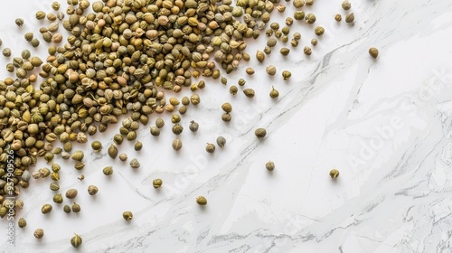 Salted capers displayed on white marble background viewed from above photo