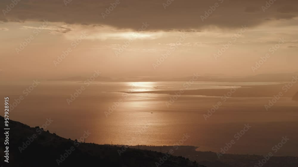 The sea glows under a golden sunset, with soft light reflecting off the water. The horizon fades into the distance, creating a tranquil and serene coastal scene near Patras, Greece. The sea glows under a golden sunset, with soft light reflecting off the water. The horizon fades into the distance, creating a tranquil and serene coastal scene near Patras, Greece.