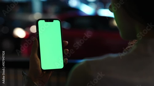 Wallpaper Mural Closeup of Young Girl Holding Smartphone with Chroma Key Watching Social Media Content Outside in the Night City Street. Torontodigital.ca