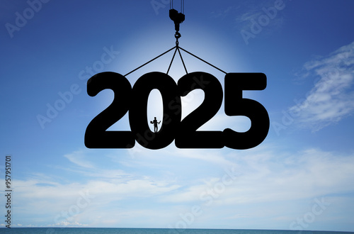 Concept Happy new year Silhouette of 2025 lifting crane with engineer standing by to supervise the work on blue sky background.