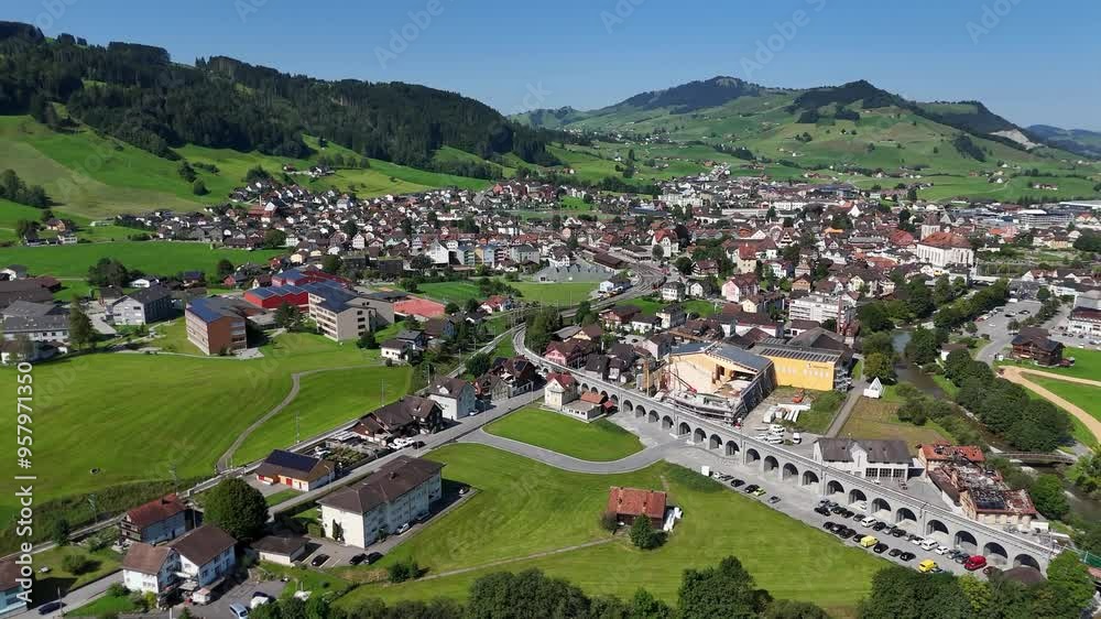 Beautiful idyllic swiss city with bridge and center at Sunny day in summer. Green fields, forest and mountain surrounded town. Aerial wide shot. Beautiful idyllic swiss city with bridge and center at Sunny day in summer. Green fields, forest and mountain surrounded town. Aerial wide shot.