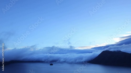 山間の湖を覆うように雲が流れる雄大な夜明け。日本の北海道の有名な景勝地の摩周湖。 photo