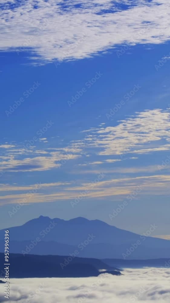 青空をゆっくりと流れる薄い雲。雄大な山の稜線。 青空をゆっくりと流れる薄い雲。雄大な山の稜線。
