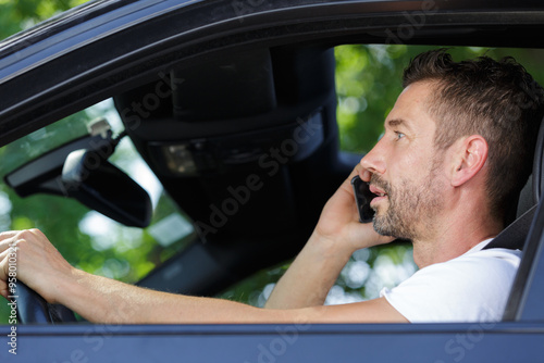 man talking on mobile phone while driving