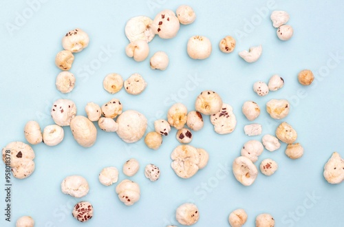 Makhana or Fox Nut Scattered on Light Blue Background with Copy Space, Also Known as Lotus Seed Pop, Euryale Ferox or Gorgon Nut