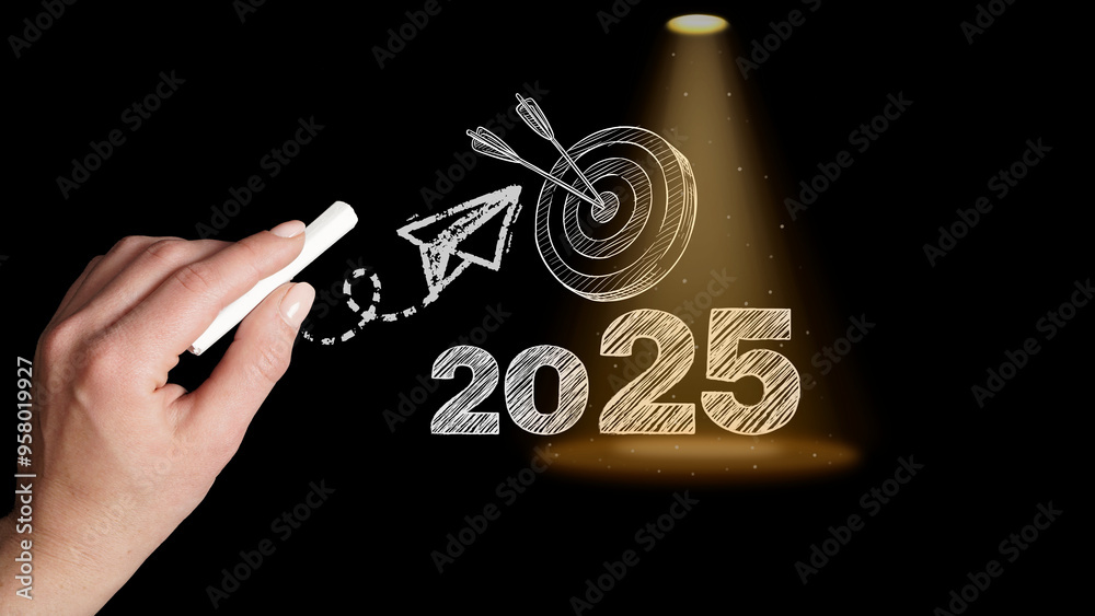 Vision 2025. Chalk outlines a bold 2025, illuminated by a spotlight, with a paper airplane