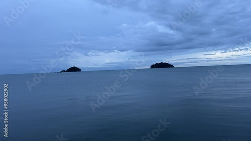Timelapse of the deep blue sea and deep blue sky with flash of lightning.
