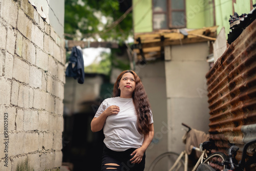 A young Filipina woman walking around an alley in a slum area, looking around her surroundings, beaming with ambition.