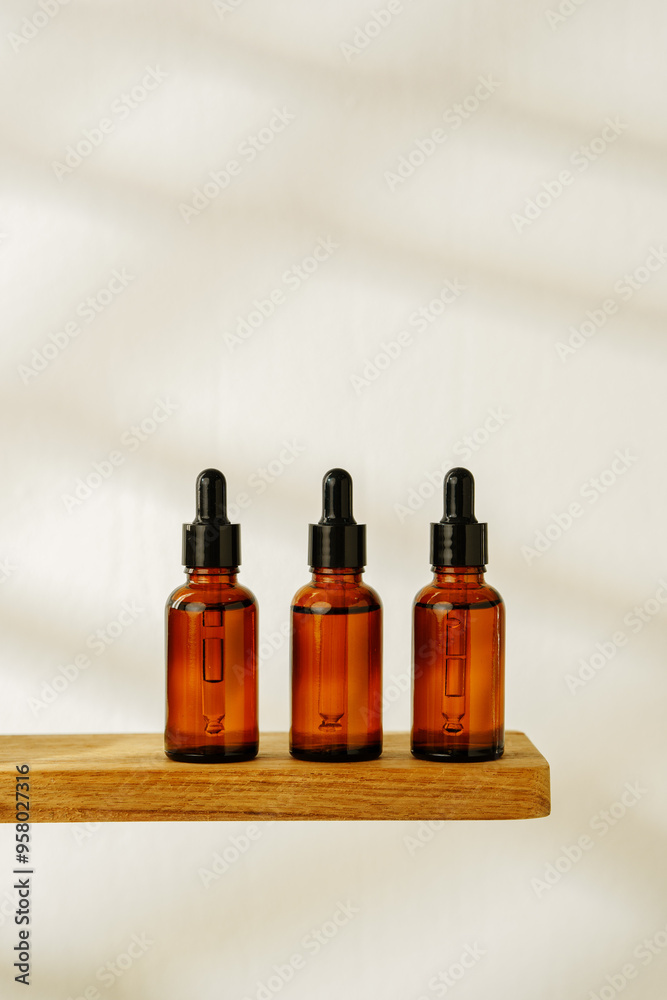 Collection of Amber Glass Dropper Bottles Displayed on a Minimalist White Surface in Natural Light