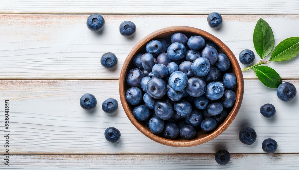 top view of fresh blueberries in bowl on white wooden table
top view of fresh blueberries in bowl on white wooden table