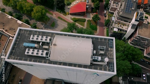 A drone shot starting with a top-down view of the Kadaster building in Apeldoorn, tilting up to reveal nearby residential flats and the city center. Location: Apeldoorn, Netherlands photo