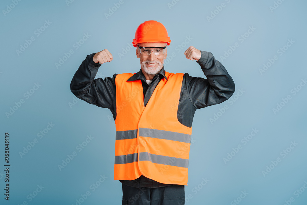 Smiling construction worker wearing hardhat and safety vest flexing muscles Smiling construction worker wearing hardhat and safety vest flexing muscles