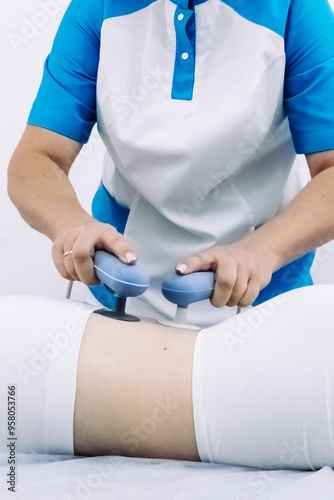 A female physiotherapist applies diathermy treatment to a patient's back, showcasing advanced techniques for pain management and muscle recovery. Ideal for illustrating expert care in physiotherapy. photo