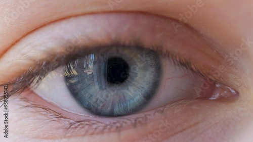 Close-up of Person's Eye With Blue Iris. Blue Eye of Child Looking at Camera Close Up. Macro Shot Opening and Closing Blue Eyes Little Girl. Motion of Children Eyes. Human Eye Iris Opening Pupil.