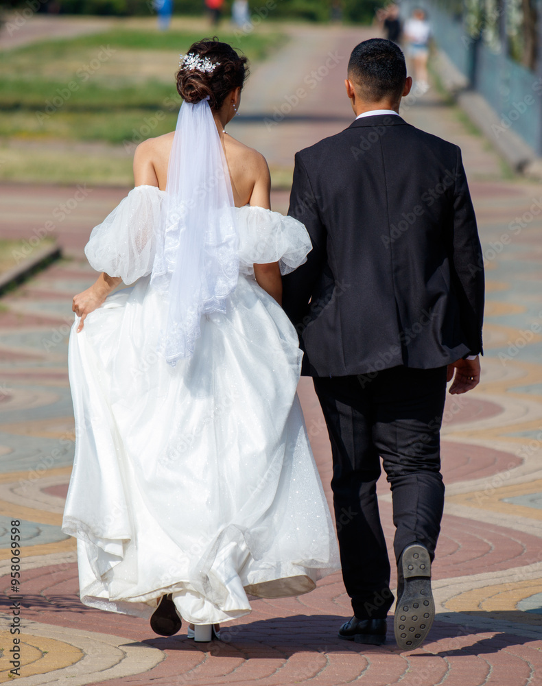 The bride in a wedding dress and the groom are walking in the park. Detailed photo The bride in a wedding dress and the groom are walking in the park. Detailed photo