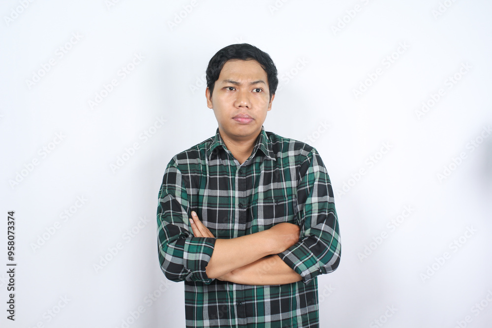 uncertain asian young man arms crossed thinking and considering decision isolated uncertain asian young man arms crossed thinking and considering decision isolated