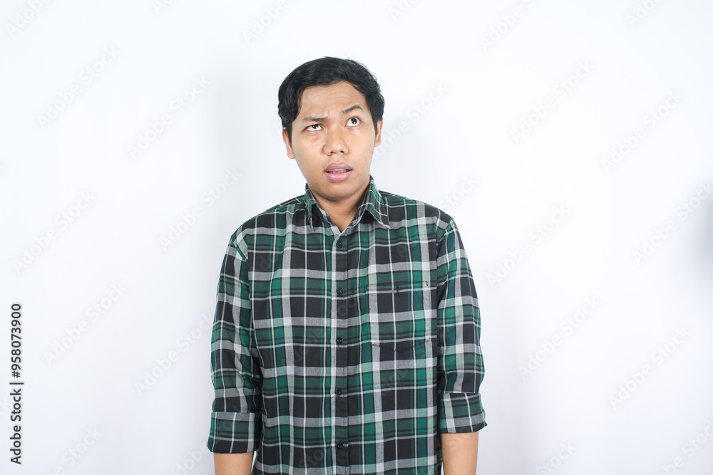 isolated clueless asian young man looking above thinking two choices and imagine something isolated clueless asian young man looking above thinking two choices and imagine something