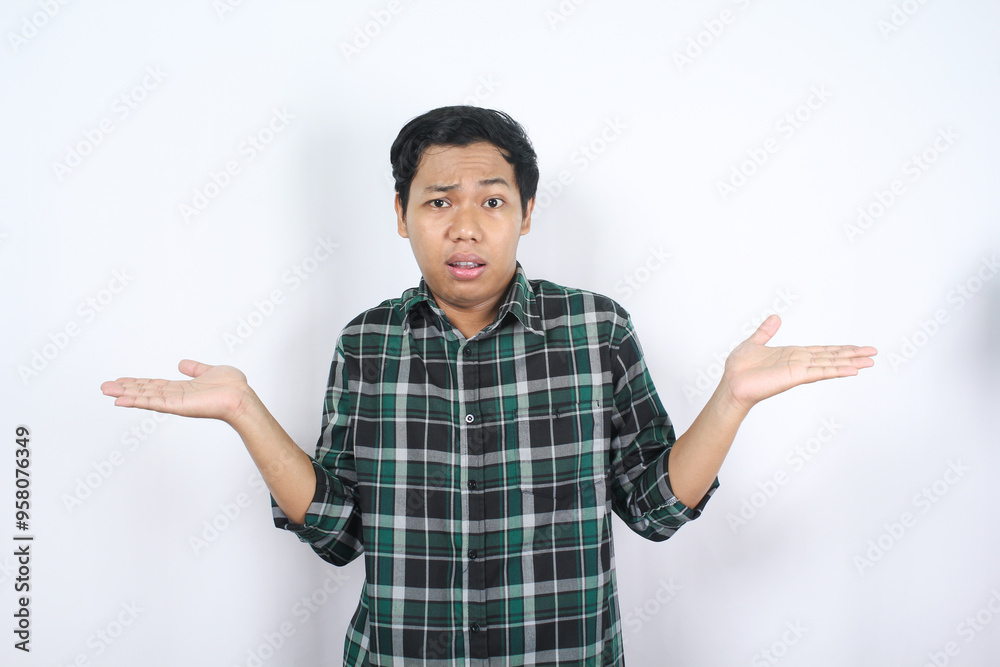 don't know gesture. clueless asian young man spreading his hand looks doubtful and uncertain wearing casual shirt isolated don't know gesture. clueless asian young man spreading his hand looks doubtful and uncertain wearing casual shirt isolated