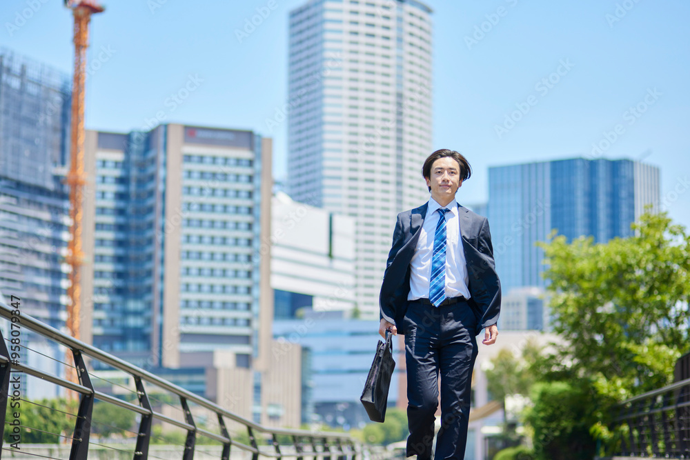 ビジネス街を歩くスーツを着た若いビジネスマン ビジネス街を歩くスーツを着た若いビジネスマン