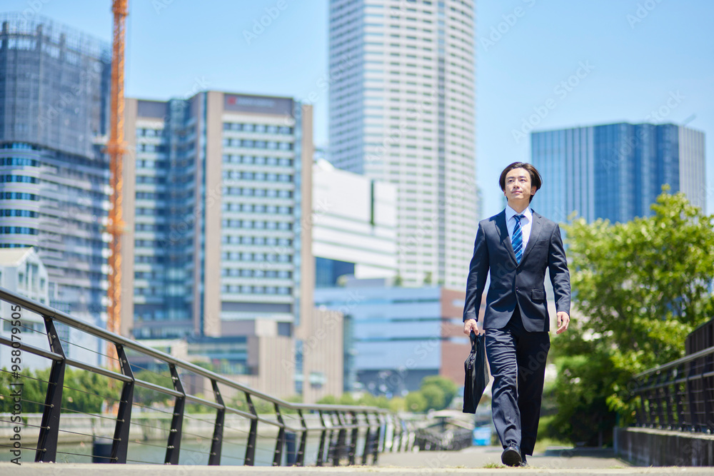ビジネス街を歩くスーツを着た若いビジネスマン ビジネス街を歩くスーツを着た若いビジネスマン