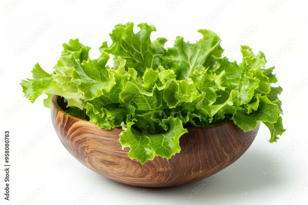 Fresh lettuce leaves overflowing a wooden bowl on a white background Fresh lettuce leaves overflowing a wooden bowl on a white background