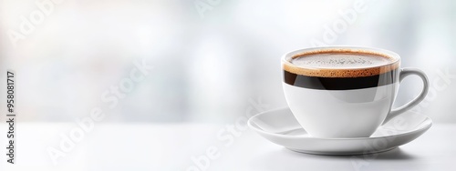  A tight shot of a steaming coffee cup on a saucer against a softly blurred white tablebackground photo