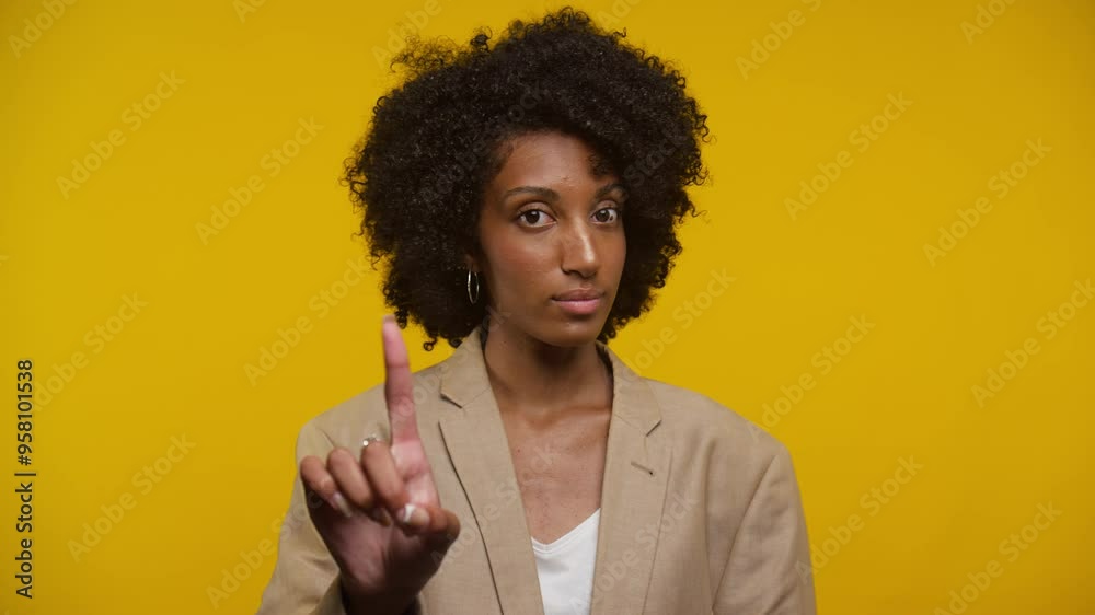 Woman with curly hair making a warning gesture with raised finger Woman with curly hair making a warning gesture with raised finger