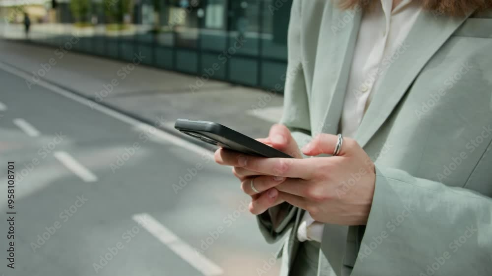 Close up shot of hands of unrecognisable business girl dressed in pantsuit surfing internet on smartphone while searching for address of office building outdoors