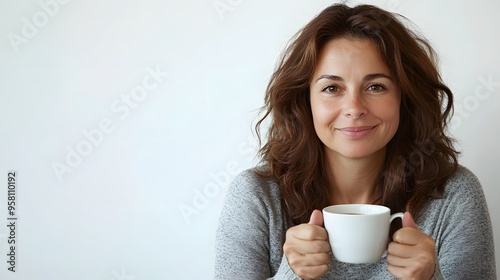 Holding a Cup: A woman sitting comfortably, holding a coffee cup with both hands, against a white background.
