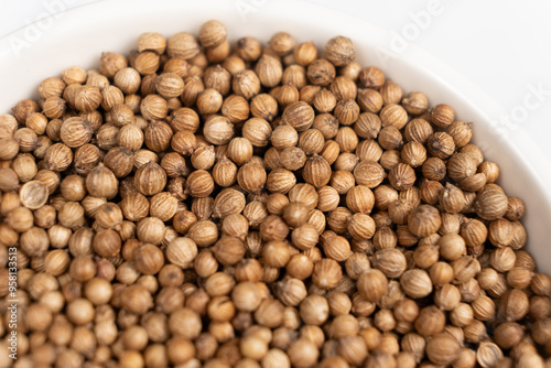 Coriander grains in a plate macro top view.