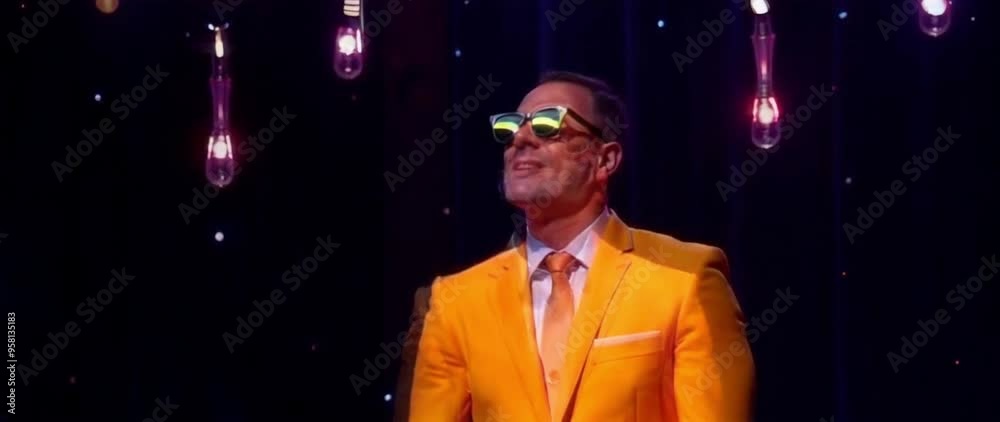 Confident Man in Orange Suit with Stylish Sunglasses Under Lights Confident Man in Orange Suit with Stylish Sunglasses Under Lights