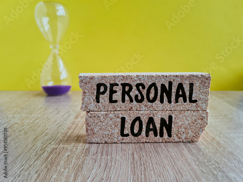 Personal Loan symbol. Brick blocks with the inscription - Personal Loan. Beautiful yellow background, wooden table. Hourglass. Business and finance concept.