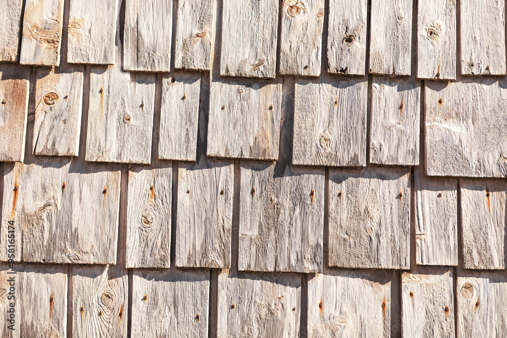 Wooden background with a pattern of wood shingles, background with wood texture. Wooden wall showcasing the texture and natural imperfections of the wood