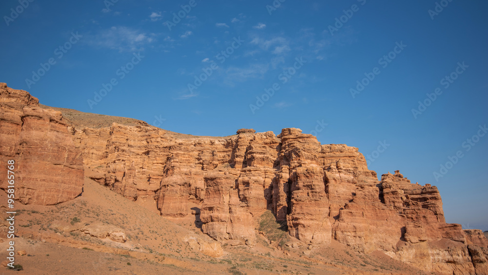 a striking range of massive red sandstone formations under a vast blue sky, hinting at a tranquil desert setting in the warm, gentle light of a late summer afternoon a striking range of massive red sandstone formations under a vast blue sky, hinting at a tranquil desert setting in the warm, gentle light of a late summer afternoon