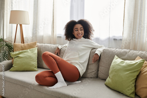 Photography A young woman lounges comfortably in her living room, radiating warmth and relaxation in loungewear