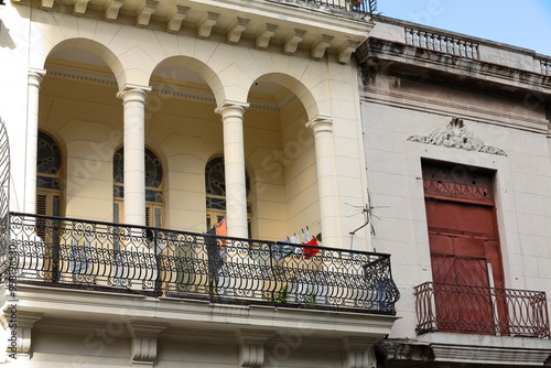 First floor of early 1900s Eclectic style building on 254 Paseo del Prado west side, cream color facade, laundry drying on balcony. Havana-Cuba-674 photo